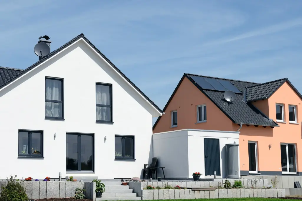 a modern white single-family home and a modern orange single-family home