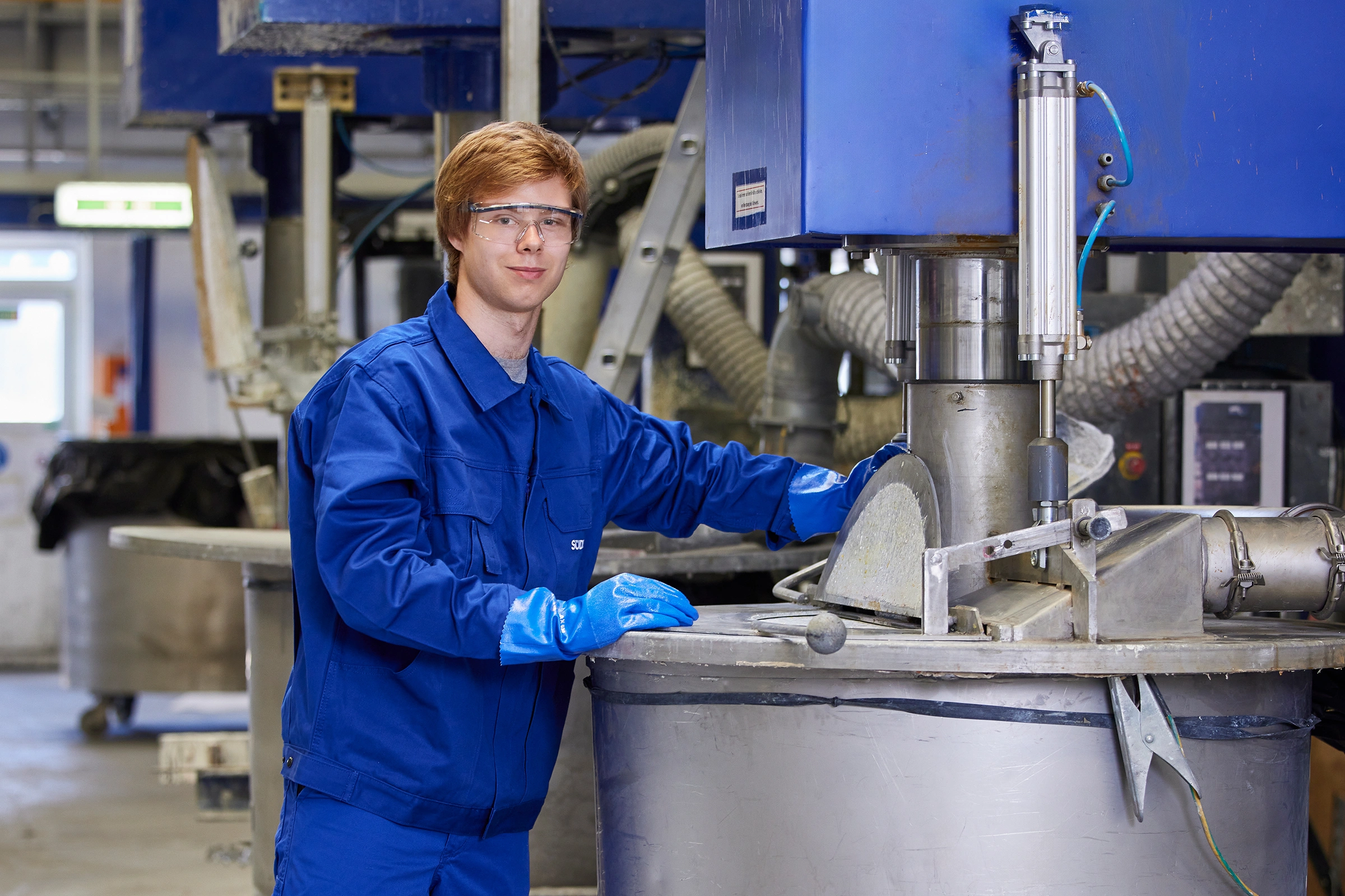 Chemical production specialist trainee together with a colleague at the machine